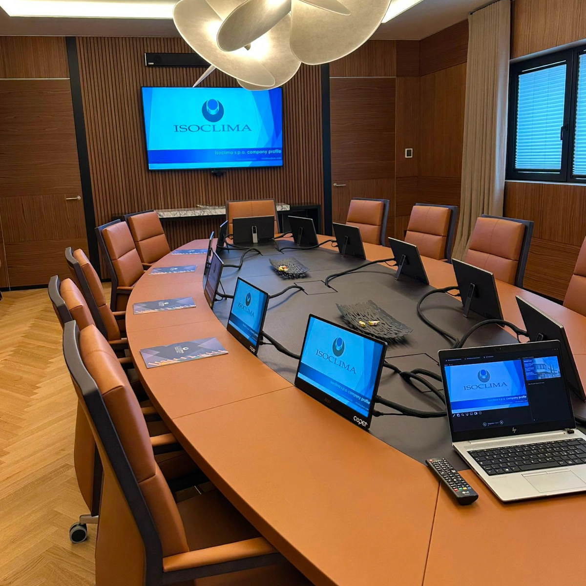 Sala riunioni Isoclima con monitor condivisi su ogni postazione e sistema per meeting ibridi