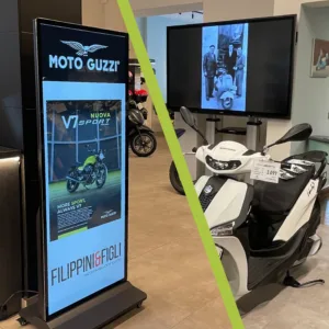 Allestimento digitale all’interno della concessionaria Filippini & Figli, con display Moto Guzzi e scooter esposti nello showroom.